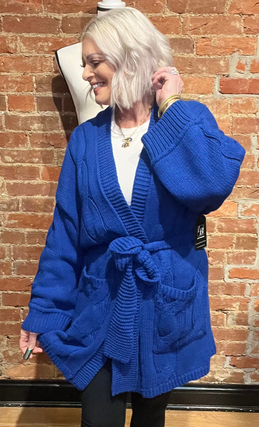 Blue cardigan sweater, relaxed fit, dropped shoulders, long sleeves, open front with waist tie wrap, pockets, kimono silhouette.